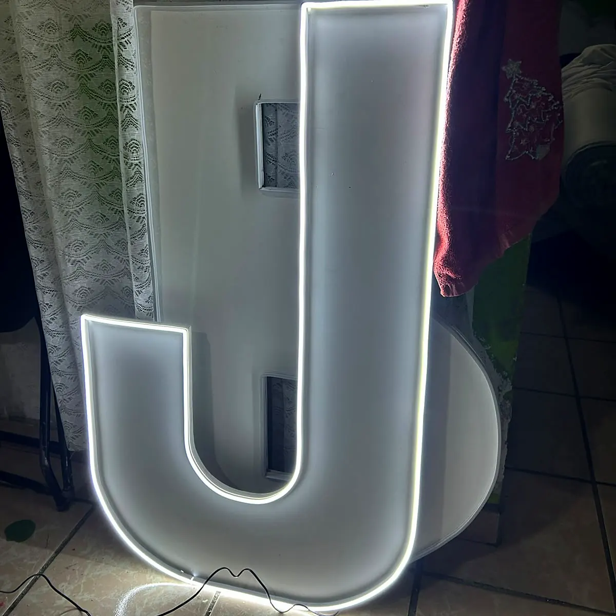 Letra J gigante iluminada con luz neón